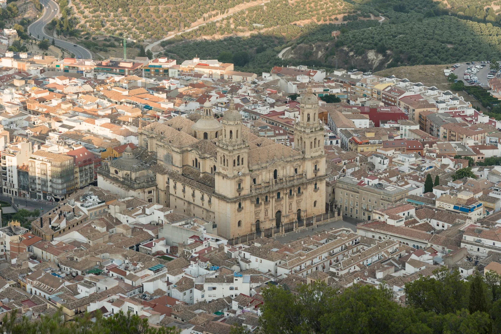 Jaén Cathedral rises above the tiled roofs of the city, seen from Santa Catalina Castle, with olive groves beyond.
